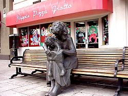 bench sculpture in front of Filippi's Pizza Grotto