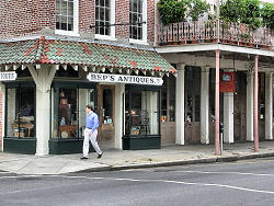 man walking on street in front of antique shop