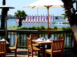 dining in front of sail boats on the bay
